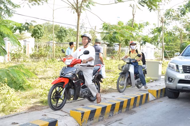 Người đi xe máy phải "vọt" lên lề để lưu thông qua trạm.