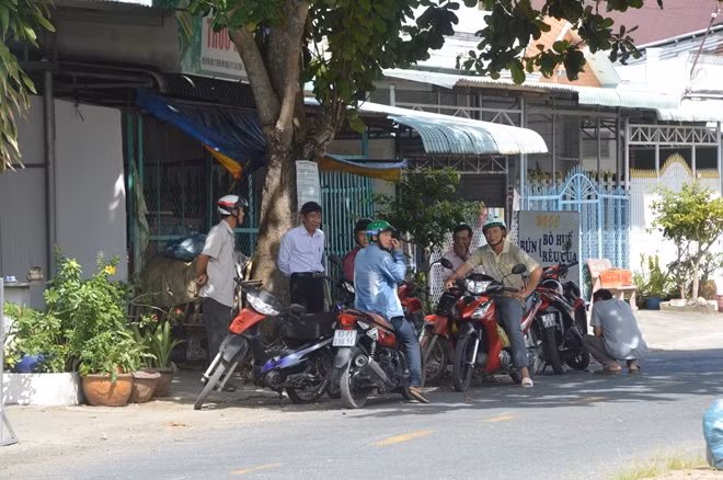 Phụ huynh chờ con dưới nắng nóng.