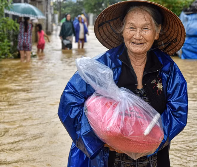 Nụ cười lạc quan của người dân vùng lũ khi nhận được phần quà cứu trợ.