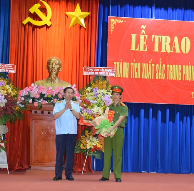 Ông Nguyễn Văn Cẩn, Tổng cục trưởng Tổng cục Hải quan, trao thưởng 100 triệu đồng cho đại diện Ban chuyên án.