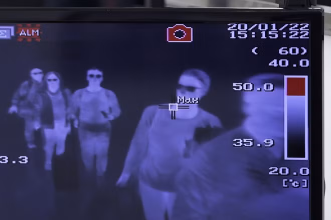 Đoàn người đi qua camera có chức năng đo thân nhiệt để tìm kiếm những người có nguy cơ mắc COVID-19. Ảnh: ITN