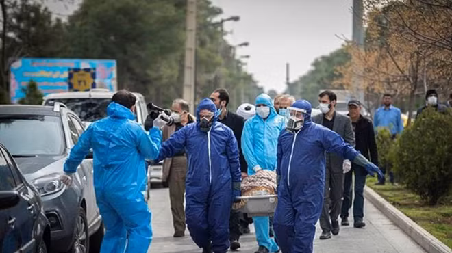 Nhân viên y tế Iran di chuyển thi thể một bệnh nhân nhiễm COVID-19. Ảnh: Reuters