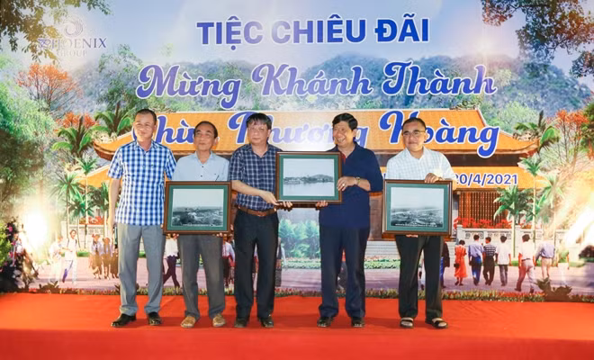 Đại tá Phạm Khải trao ảnh tặng ông Nguyễn Văn Hùng và Tập đoàn Quốc tế Phượng Hoàng.