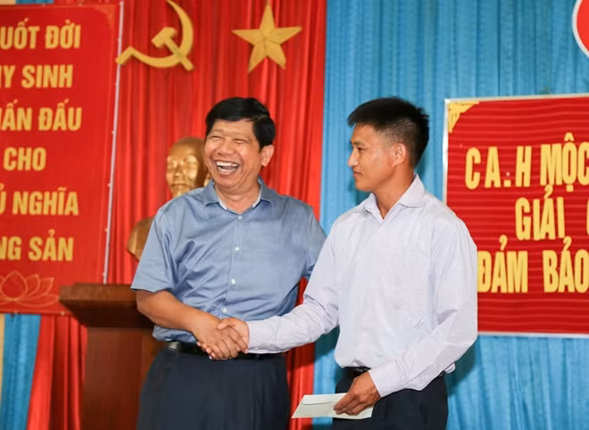 Ông Nguyễn Văn Hùng (bìa trái) động viên, tặng quà anh Hạng A Sò.