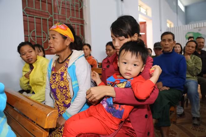 Em nhỏ được mẹ đưa tới UBND xã Hương Liên nhận quà từ đoàn công tác Báo CAND, TMV Ngọc Dung và Công ty Duy Lợi.