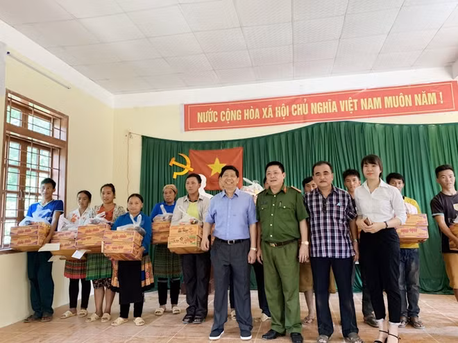 Đại diện Công an huyện Mộc Châu và Tập đoàn Phượng Hoàng trao quà tặng người dân Pha Đón.