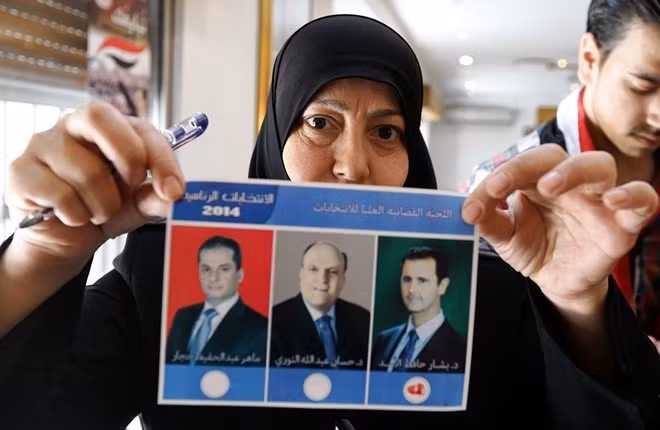 Một phụ nữ Syria cầm lá phiếu trong cuộc bầu cử tổng thống năm 2014. Ảnh: WSJ