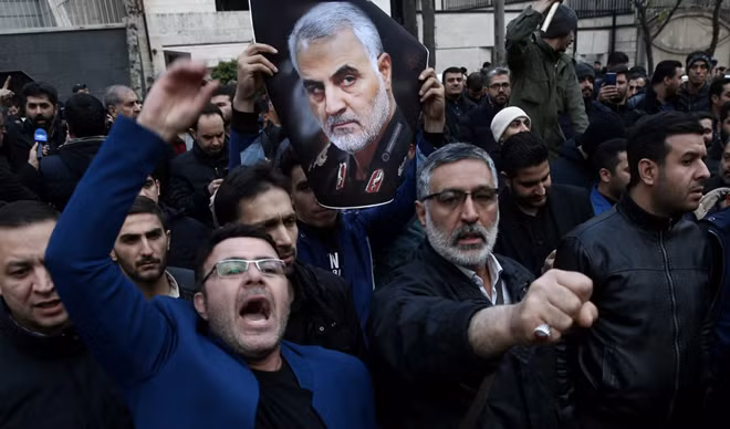 Người biểu tình mang di ảnh của tướng Soleimani. Ảnh: Reuters