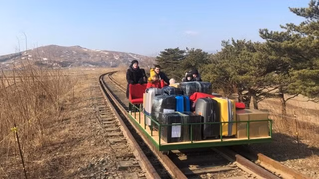 Các nhà ngoại giao Nga đẩy xe tự chế để đưa gia đình và đồ đạc về nước. Ảnh: RT Các nhà ngoại giao Nga đẩy xe tự chế để đưa gia đình và đồ đạc về nước. Ảnh: RT