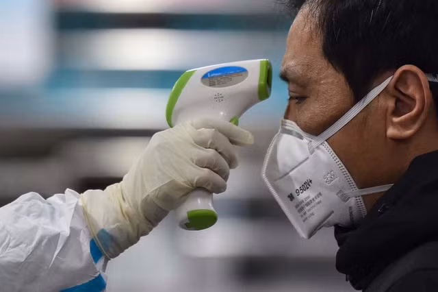 Nhân viên y tế đo nhiệt độ một người đàn ông tại bệnh viện ở Vũ Hán. Ảnh: Getty Images Nhân viên y tế đo nhiệt độ một người đàn ông tại bệnh viện ở Vũ Hán. Ảnh: Getty Images