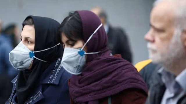 Sinh viên Iran đeo khẩu trang khi ra đường để ngăn COVID-19. Ảnh: ITN