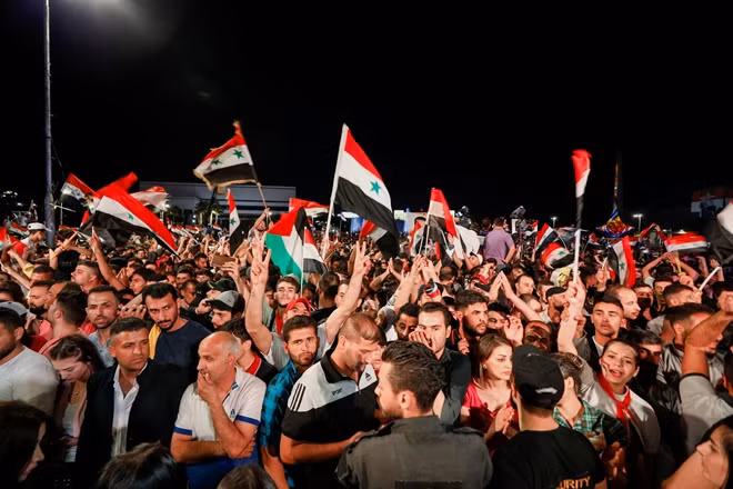 Người Syria xuống đường ăn mừng ông Assad thắng cử. Ảnh: Reuters