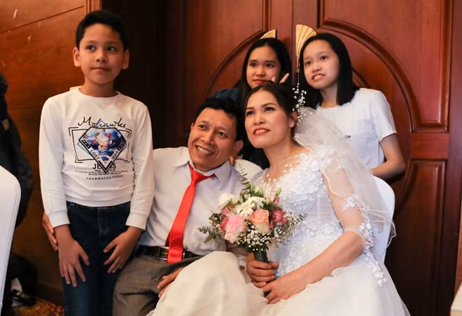 Anh Nguyễn Như Thuận, chị Nguyễn Thị Hiền, trú tại Thạch Thất và ba con của anh chị tại lễ cưới. Anh Thuận bị viêm cột sống dính khớp, đi lại rất khó khăn. Anh kể, vợ chồng anh đã sống với nhau gần 20 năm, con lớn học lớp 11. "Bà ấy tán tôi trước đấy", anh Thuận hóm hỉnh nói và cho biết, ngày xưa, anh chị đã làm vài mâm mời họ hàng, nhưng chưa từng làm đám cưới hoành tráng thế này.