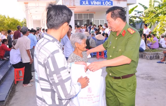 Đại tá Lê Thái Nguyên - Trưởng Công an huyện Hồng Dân trao quà và thăm hỏi sức khỏe người dân.