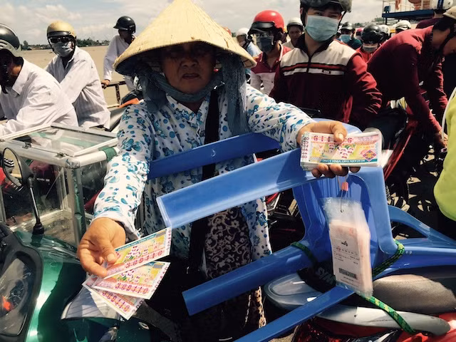 Đều cùng mục đích ích nước lợi nhà, giữa vé số truyền thống và vé số Vietlott cần có sự hài hòa, chia sẻ thị phần một cách hợp lý. Trong ảnh: Người phụ nữ nghèo này mưu sinh bằng nghề bán vé số (cả vé số truyền thống lẫn Vietlott) trên chuyến đò ngang vượt sông Hậu từ Cần Thơ sang Vĩnh Long. Đều cùng mục đích ích nước lợi nhà, giữa vé số truyền thống và vé số Vietlott cần có sự hài hòa, chia sẻ thị phần một cách hợp lý. Trong ảnh: Người phụ nữ nghèo này mưu sinh bằng nghề bán vé số (cả vé số truyền thống lẫn Vietlott) trên chuyến đò ngang vượt sông Hậu từ Cần Thơ sang Vĩnh Long.