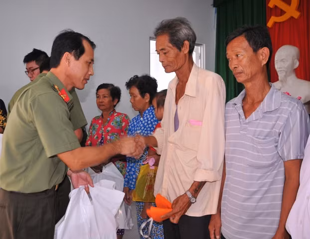 Trung tá Hồ Văn Dũng – bác sĩ CKII, Phó Cục trưởng Cục Y tế - Trưởng đoàn công tác trao quà cho người dân.