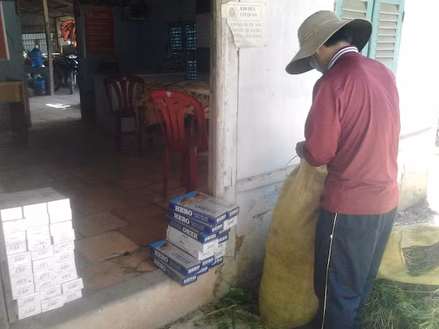 Ẩn cùng số thuốc lá được nguỵ trang trong bao cỏ.