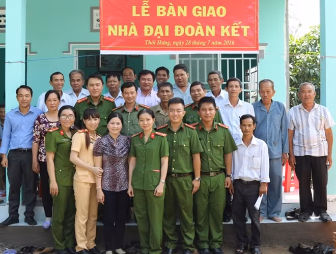 Phòng cảnh sát kinh tế Công an TP Cần Thơ chụp ảnh lưu niệm cùng 2 gia đình tại lễ trao nhà.