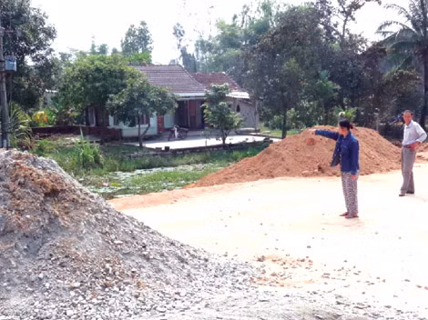 Bà Thảo chỉ ranh giới nhà mình và nhà ông Sơn, trong khi đống đá dăm được đổ cách đó chừng 7-10m.