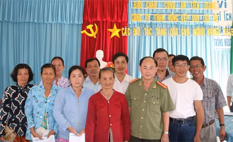 Đại tá Trần Kim Thẩm, ông Lâm Tấn Lợi và các đối tác, tặng quà Tết bà con nghèo xã Mỹ Hội, huyện Cái Bè.