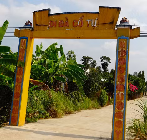 Lối vào chùa Di Đà Cổ Tự và những khóm hoa dừa cạn trong sân chùa.
