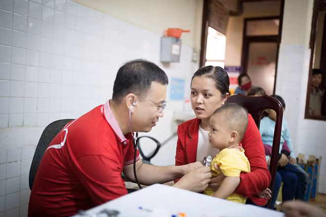 Các bác sĩ đang khám sàng lọc miễn phí cho trẻ em nghèo.