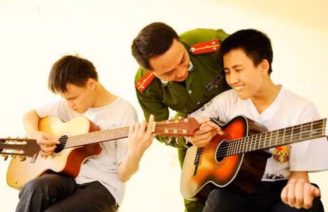 Thượng uý Trần Anh Tuấn dạy đàn cho các học sinh Trường khiếm thị Nguyễn Đình Chiểu - Ảnh Nguyễn Xuân Chính.
