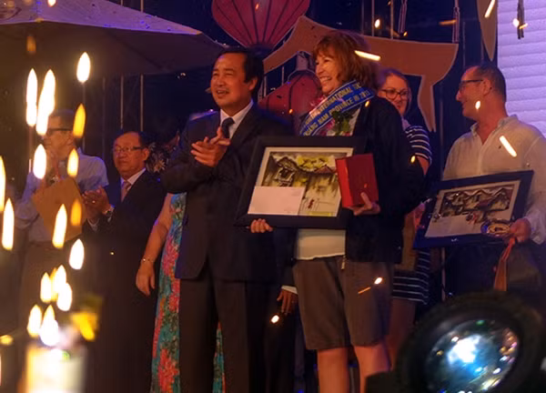 Đón du khách thứ 1,8 triệu đến Quảng Nam năm 2015 và đoàn du lịch của mình. Ảnh: Hà Ngọc.