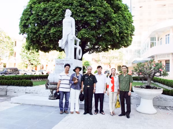 Thiếu tướng, bác sĩ Nguyễn Văn Hoàng Đạo chụp ảnh lưu niệm với CBCS Công an tỉnh Thanh Hóa dưới tượng đài Liệt sĩ CAND Nguyễn Thị Lợi.