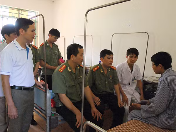 Đại diện lãnh đạo Phòng Công tác chính trị và lãnh đạo Công an huyện Thông Nông trao số tiền hỗ trợ của Báo CAND và Công an huyện Thông Nông cho anh Triệu Văn Sỳ.