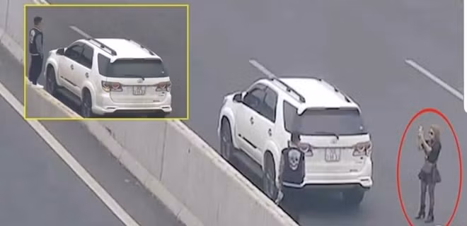 Chị Bùi Thị L. dừng xe để chụp ảnh bị camera ghi lại.