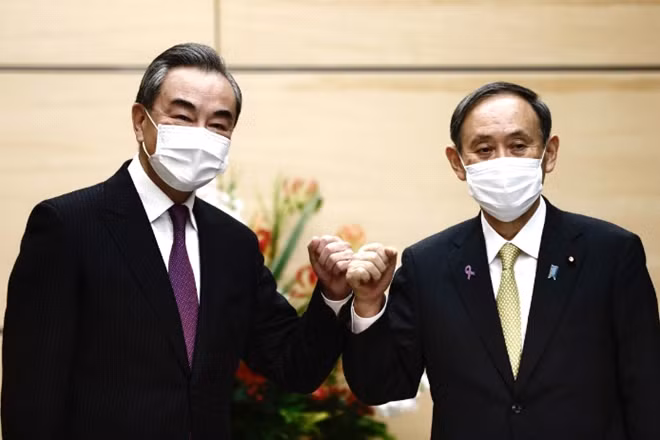 Thủ tướng Nhật Bản Yoshihide Suga (phải) và Ngoại trưởng Trung Quốc Vương Nghị. Ảnh: Bloomberg.