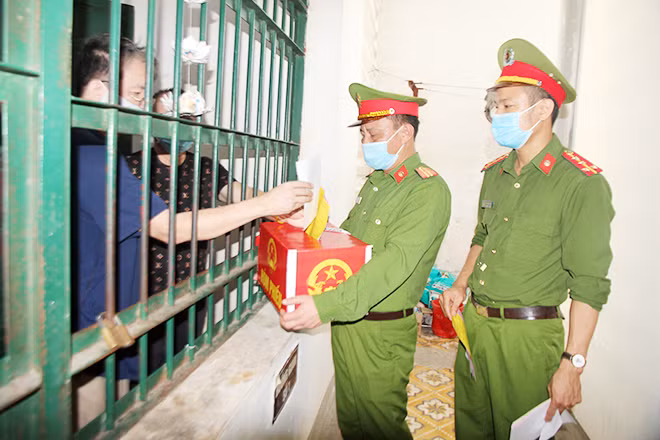 Hòm phiếu phụ lưu động được đưa đến từng buồng giam để cử tri nhận phiếu bầu và thực hiện việc bầu cử của mình.