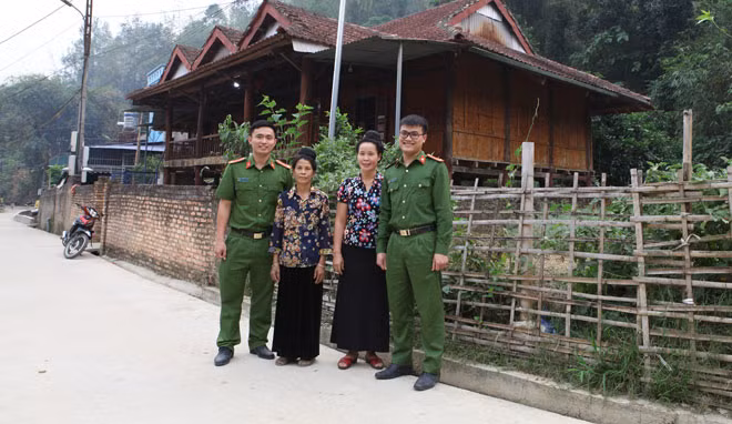 Trung úy Phan Đức Lộc (phải) và đồng đội chụp ảnh kỷ niệm cùng dân bản trong một chuyến công tác.