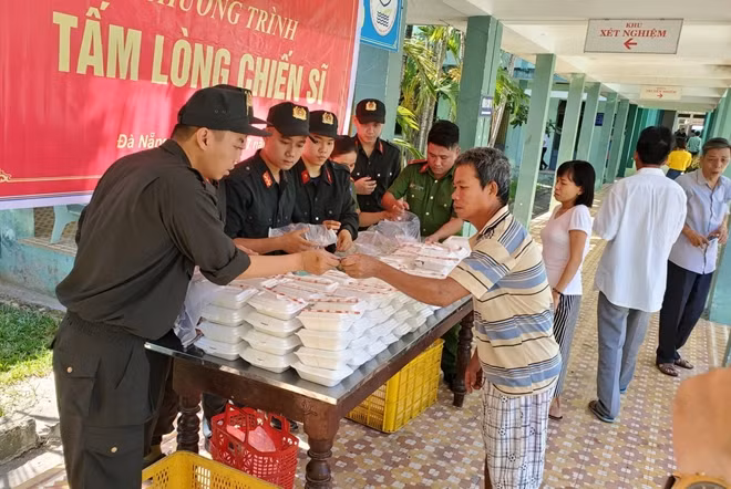 Các CBCS Phòng CSCĐ Công an TP Đà Nẵng phát cơm từ thiện cho bệnh nhân nghèo tại Trung tâm Y tế quận Cẩm Lệ.