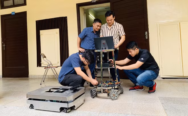 TS. Ngô Mạnh Tiến (đứng, áo kẻ xanh) và nhóm sáng chế.