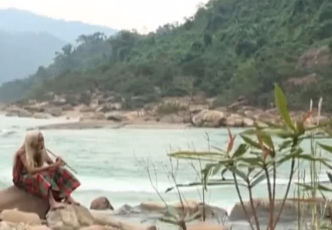 Nghệ nhân Hồ Ai thổi sáo Pi bên thác Tam Lu.