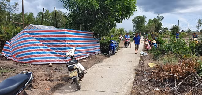 Thi thể cháu bé được đưa lên bờ để trong lều bạt để chờ lực lượng chức năng đến khám nghiệm.