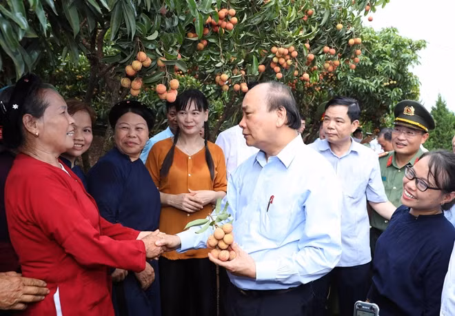 Thủ tướng Nguyễn Xuân Phúc nói chuyện với nhân dân địa phương khi đến thăm Vườn quả Bác Hồ. Ảnh: TTXVN