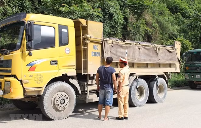 Cảnh sát giao thông kiểm tra một xe tải lưu thông trên đường. Ảnh minh họa. (Nguồn: TTXVN)