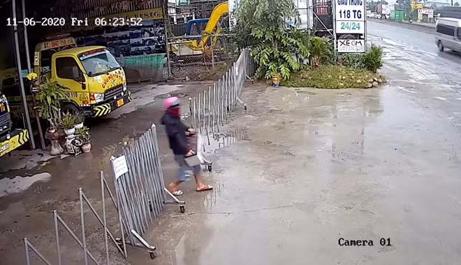 Nam thanh niên đi vào bãi xe và lấy trộm bình ắc quy mang ra ngoài rồi lên xe tẩu thoát.