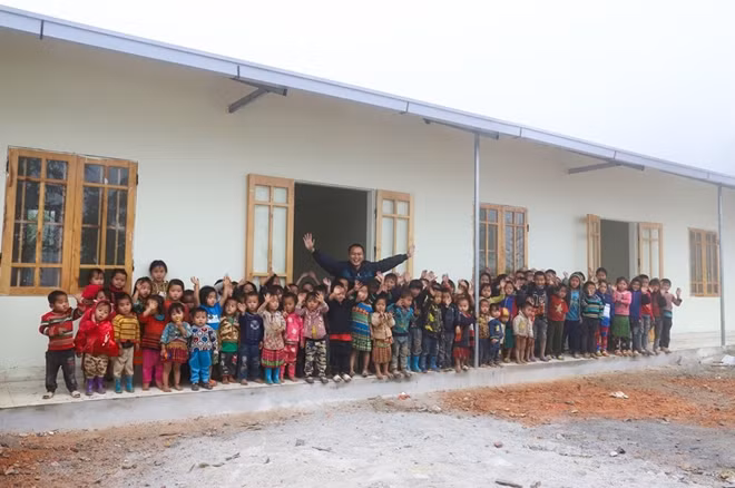 Anh Phạm Đình Quý và các em học sinh miền núi trước lớp học mới ấm áp tình người - Nguồn ảnh: Báo Lao động.