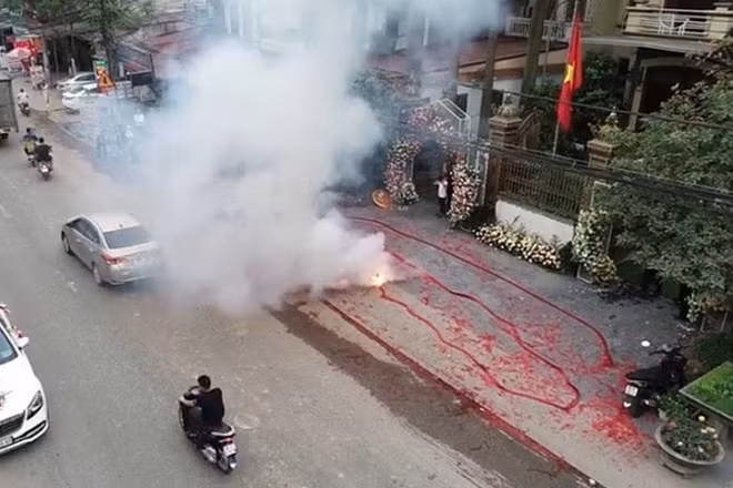 Khói từ pháo đốt bốc lên trắng xóa, xác pháo đỏ ngổn ngang trên mặt đường.