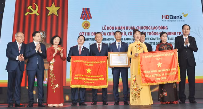 Ông Lê Thanh Liêm, Phó Chủ tịch thường trực UBND TP.HCM trao Cờ Truyền thống cho Ban Lãnh đạo HDBank.