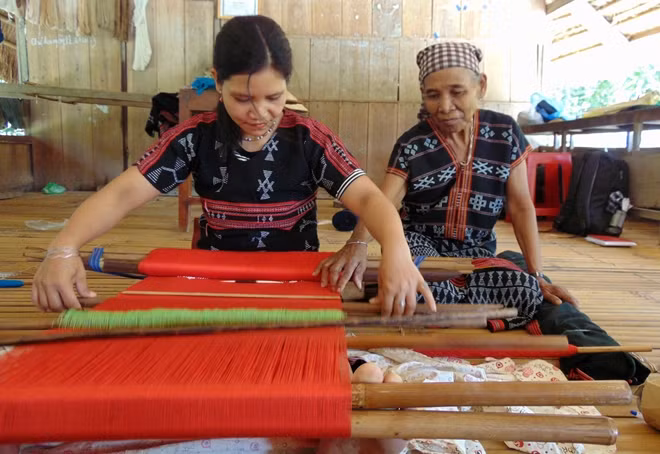Bà Zơ Rum Rem dạy cách dệt vải cho chị Ria Viết.