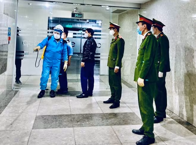 Lực lượng công an giám sát việc phun thuốc khử khuẩn.