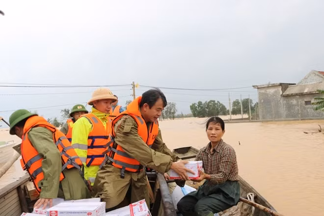Đại tá Nguyễn Tiến Nam - Giám đốc Công an tỉnh Quảng Bình cùng cán bộ, chiến sĩ chèo đò vào hỗ trợ người dân vùng lũ.