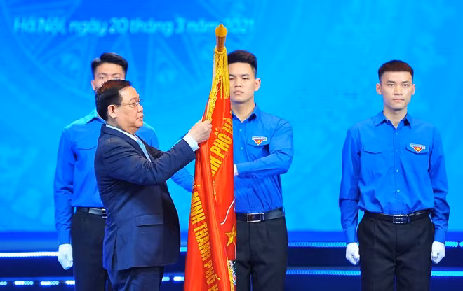Bí thư Thành uỷ Hà Nội Vương Đình Huệ gắn Huân chương Lao động hạng Nhất lên cờ truyền thống của Thành đoàn Hà Nội. Ảnh: TTXVN