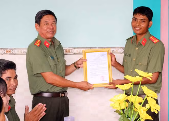 Đại tá Huỳnh Văn Thình trao quyết định tặng nhà đồng đội cho Trung úy Thạch Tranh Nặng, cán bộ phòng An ninh đối nội.