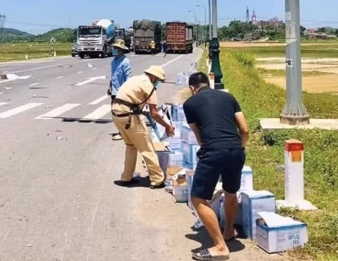 CSGT cùng người dân hỗ trợ thu gom thùng và chai nước cho tài xế.